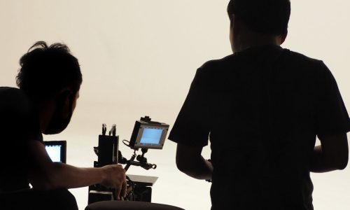 Behind the scenes of silhouette working people that making movie or tv channel content or film in big studio with camera set and production crew team.